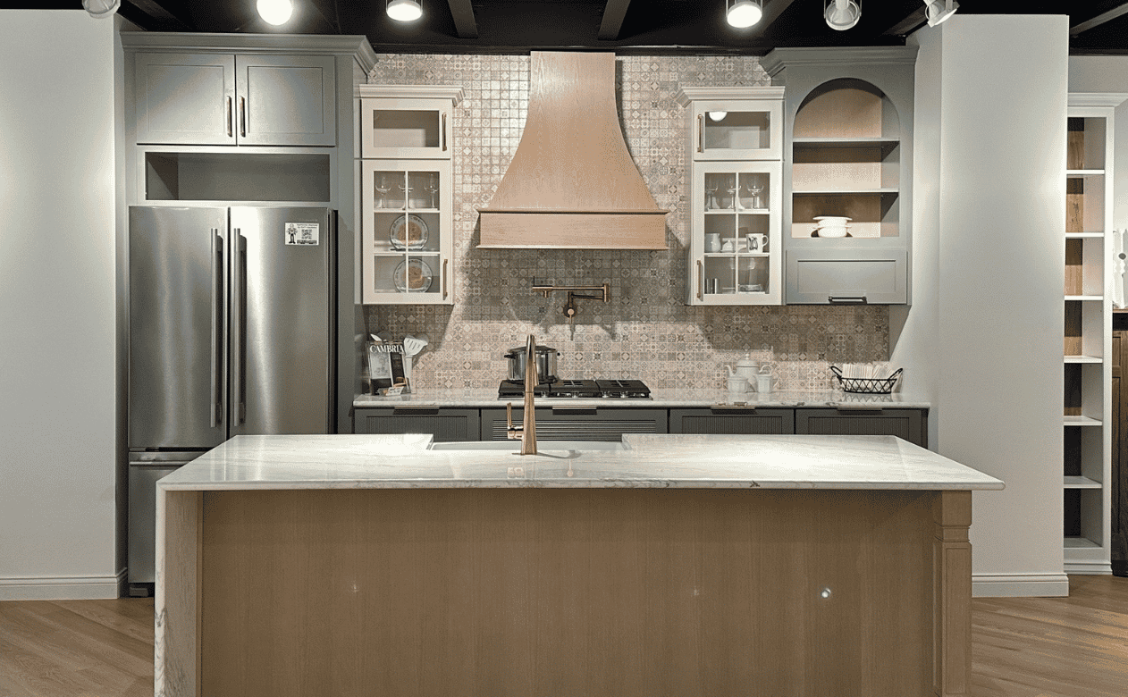 Kiba kitchen with large island and green, natural, and white cabinetry
